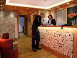 un homme et une femme debout dans un bar dans l'établissement Hotel Plateau Rosa, à Zermatt