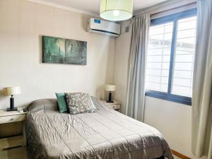 1 dormitorio con 1 cama, escritorio y ventana en Manantiales en Villa Carlos Paz