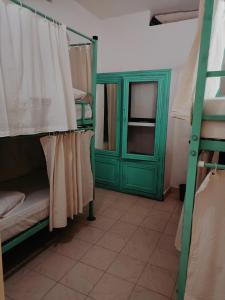 um quarto com beliches e uma porta verde em Molly's Hostel em Varkala