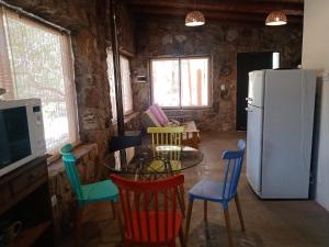 cocina con mesa, sillas y nevera en Los chañares en San Javier