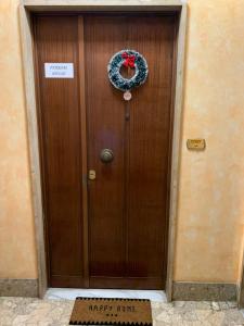 una puerta de madera con una señal de happy hour en Ferrari House, en Roma