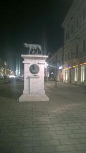 a monument with a cat on top of it at night at M Central Apartments in Cluj-Napoca