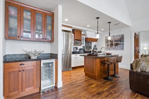 una cucina a pianta aperta e un soggiorno con armadi in legno di Luxury Penthouse At Solar A Resort And Spa a Canmore
