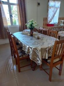 una mesa de comedor con un jarrón de flores. en Kazkreole en Mont Blanc