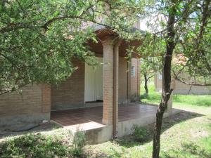a brick house with a porch and a white door at Ayres Serranos in Merlo