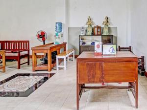 ジョグジャカルタにあるOYO 91920 Pondok'ku Innの木製テーブルと椅子が備わる部屋