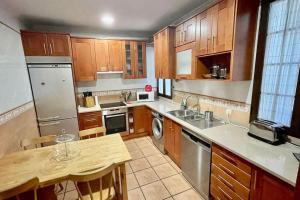 a kitchen with wooden cabinets and stainless steel appliances at Amplio piso en centro histórico. in Toledo