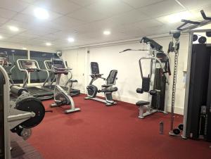 einen Fitnessraum mit mehreren Laufbändern und Heimtrainern in der Unterkunft Studio for Professionals Trades Relocators in Cardiff
