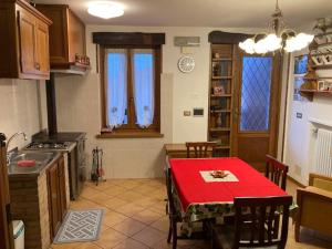 a kitchen with a table with a red table cloth at Casa vacanza da Berto in Stregna