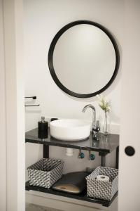 a bathroom with a sink and a mirror on a shelf at Casa suig in Baena