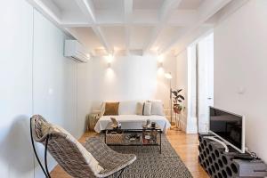 een witte slaapkamer met een bed en een televisie bij O Aleph, irresistible duplex apt. w/AC and balcony in Porto