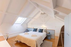 een slaapkamer met een groot wit bed en handdoeken bij O Aleph, irresistible duplex apt. w/AC and balcony in Porto