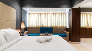 Un dormitorio con una gran cama blanca y una ventana en Niranjana Hotel Bodhgaya, en Bodh Gaya