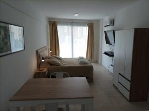 1 dormitorio con cama y mesa frente a una ventana en Palermo Hollywood Apartment en Buenos Aires