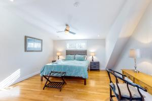 a bedroom with a bed and two chairs at Chic Spacious Home Half a Mile From Commercial Street in Provincetown