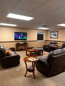 a waiting room with leather couches and a flat screen tv at Ambridge Inn in Ambridge