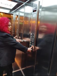 a woman with red hair standing in front of an elevator at Vila Sonnet in Korçë