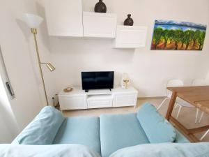 sala de estar con sofá azul y TV en Bergamo Allegra, en Bérgamo