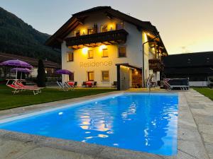 a house with a swimming pool in front of a house at Residence Untermoarhof in Brunico