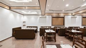 a restaurant with tables and chairs in a room at Niranjana Hotel Bodhgaya in Bodh Gaya