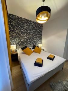 1 dormitorio con cama blanca y almohadas amarillas en Apartament Pileckiego Nowy Dwór Mazowiecki Modlin Airport, en Nowy Dwór Mazowiecki