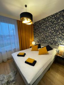 a bedroom with a large bed with yellow and black pillows at Apartament Pileckiego Nowy Dwór Mazowiecki Modlin Airport in Nowy Dwór Mazowiecki