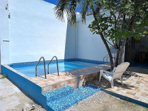 a swimming pool with a chair next to a tree at Blue Coconut Cancun Hotel in Canc&uacute;n