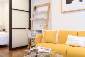 uma sala de estar com um sofá amarelo e uma mesa em 69-4A Quality NEW Prime Lower East East 1br Apt em Nova York