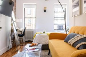 sala de estar con sofá amarillo y escritorio en 24-16 Studio Gramercy W D gramercy, en Nueva York