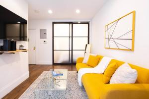 a living room with a yellow couch and a table at 69-3C Stylish Lower East East 1br Apt BRAND NEW in New York