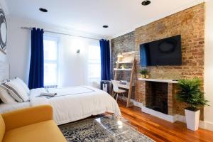 a bedroom with a brick wall with a bed and a fireplace at 24-17 Renovated Studio Prime Location WD in New York