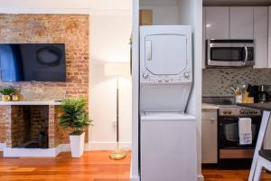 a white refrigerator in a kitchen with a fireplace at 24-17 Renovated Studio Prime Location WD in New York