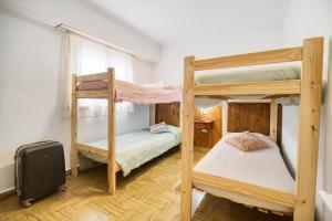 a bedroom with two bunk beds and a suitcase at Hostel BILL & BILL in Mar del Plata