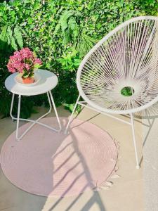 twee stoelen en een tafel en een tafel met bloemen bij CLICHY SOUS BOIS APPARTEMENT RÉCENT & CHALEUREUX in Clichy-sous-Bois