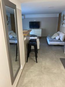 een woonkamer met een spiegel, een tafel en een bank bij CLICHY SOUS BOIS APPARTEMENT RÉCENT & CHALEUREUX in Clichy-sous-Bois