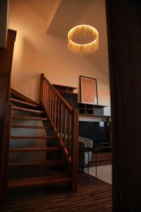 a hallway with a staircase and a chandelier at Apartment Vila Aston in Veľká Lomnica