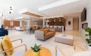 a lobby with a couch and tables and chairs at Strata Hotel in Kingston