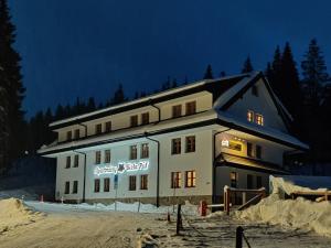 a large building in the snow at night at Apartmány Biela Púť - Jasná nr. 12 in Demanovska Dolina