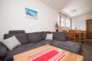 a living room with a gray couch and a table at Apartmány Biela Púť - Jasná nr. 12 in Demanovska Dolina