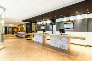 a lobby with a reception desk in a building at ibis München Parkstadt Schwabing in Munich