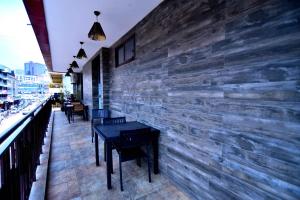 um restaurante com mesas e cadeiras e uma parede de tijolos em Victoria Mews Hotel em Kampala