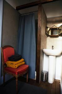 a bathroom with a red chair and a sink at Château de Bouillancourt en Sery in Bouillancourt-en-Séry