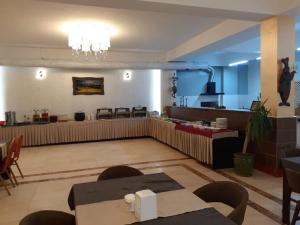 a restaurant with a waiting area with tables and chairs at Hotel Sinaia Palace in Erbil