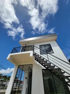 a white house with a staircase on top of it at Modern - Wan Pipel with Terrace in Paramaribo