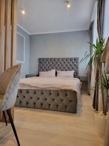 a bedroom with a large bed with a tufted headboard at Smart Studio 76 -2 in Onești