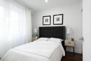 809-2A Gorgeous 1BR New W D Modern Best Location في نيويورك: غرفة نوم بيضاء بسرير كبير وموقف ليلتين