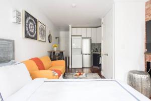 a living room with an orange couch and a kitchen at 24-9 New Prime Gramercy Subway W D in unit in New York