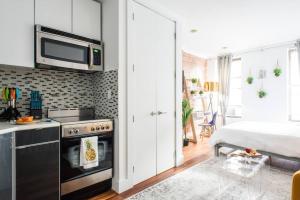 a kitchen with a microwave above a stove and a bed at 24-9 New Prime Gramercy Subway W D in unit in New York