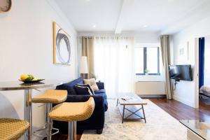 ein Wohnzimmer mit einem blauen Sofa und einem TV in der Unterkunft 809-4A Columbus Circle New BLDG 1BR W D in New York