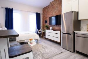 um quarto com uma cama e uma cozinha com um frigorífico em 240-14 NEW Studio Prime Location W&D in unit em Nova Iorque